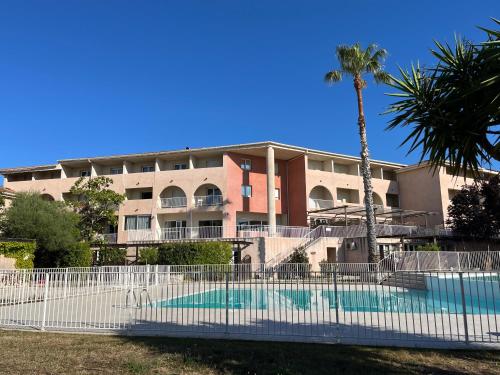 un immeuble avec une piscine devant un immeuble dans l'établissement SAINT-FLORENT 2 Pièces terrasse piscine FLO300-J07, à Saint-Florent