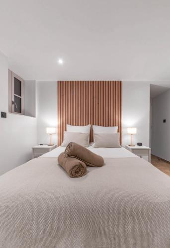 a white bed with two pillows on top of it at Résidence Jaures - Appartements design et climatisés en centre ville in Vichy