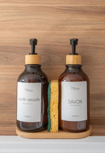 two bottles of soap sitting on a wooden shelf at Résidence Jaures - Appartements design et climatisés en centre ville in Vichy