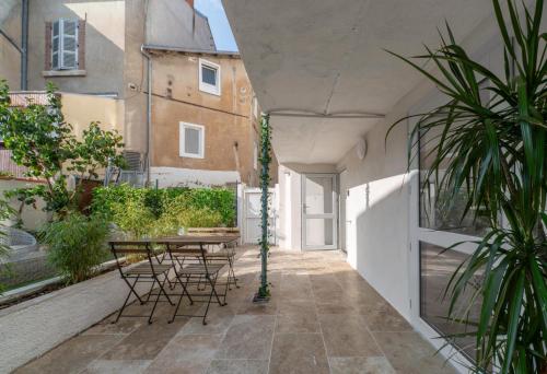 a courtyard with a table and chairs in a building at Résidence Jaures - Appartements design et climatisés en centre ville in Vichy