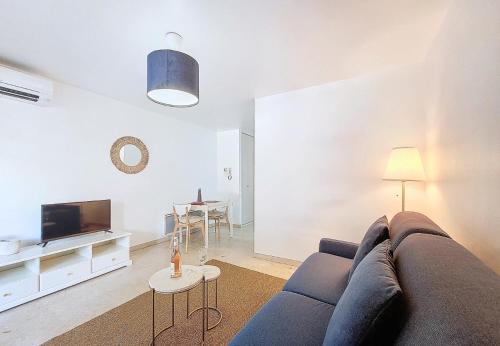 un salon avec un canapé bleu et une télévision dans l'établissement Nestor&Jeeves - KALLISTA - Central - Balcony, à Nice