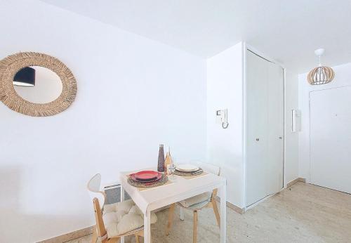 - une table et des chaises blanches dans une pièce avec un miroir dans l'établissement Nestor&Jeeves - KALLISTA - Central - Balcony, à Nice
