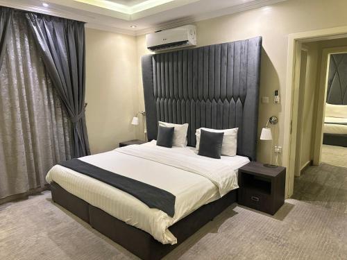 a bedroom with a large bed with a black headboard at شقق ربيع الخزمى للشقق المخدومة rabie alkhozama for serviced apartmentp in Al Khobar