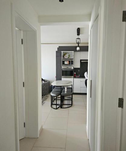 a white kitchen with a table and a table at Marassi luxury 2 bedroom in El Alamein