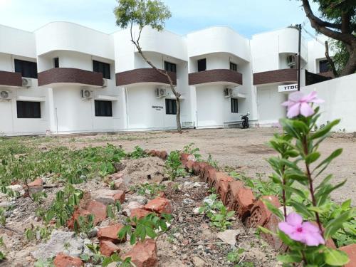 an exterior view of a building with pink flowers at Hotel Tamilnadu-Unit 2 in Rāmeswaram
