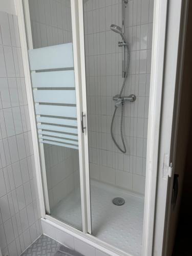 une douche avec une porte vitrée dans une salle de bain dans l'établissement Chambres d'hôtes Des Tours à La Rochelle, à La Rochelle