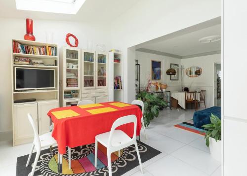 a dining room with a red table and white chairs at Wavertree Hotel in London