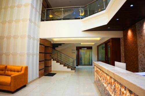 a lobby with a staircase and an orange chair at AK Castle Suites in Bengaluru