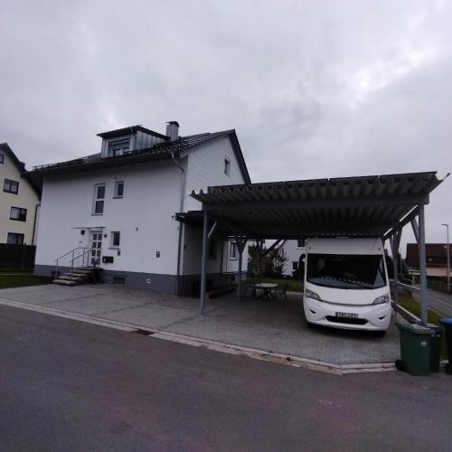 a white van parked under a building with a roof at Unterkunft 1D in Neunkirchen am Brand