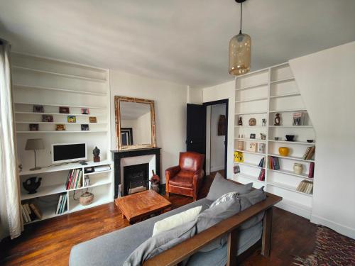 un salon avec un canapé et une cheminée dans l'établissement Summer price Beau 3 pièces près de Montmartre 1, à Paris