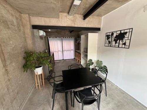 a dining room with a black table and chairs at DOCTA Residencia in Cordoba