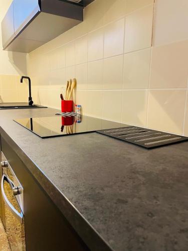 - un comptoir de cuisine avec une coupe rouge et des ustensiles en bois dans l'établissement Poirier 7, à Orléans