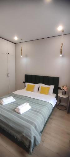 a bedroom with a large bed with yellow pillows at Riviera apartment for 6 persons in Almaty