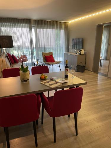 a living room with a table and red chairs at Schlosshotel Monrepos in Ludwigsburg
