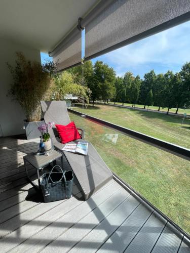 a deck with a bench and a table and a large window at Schlosshotel Monrepos in Ludwigsburg