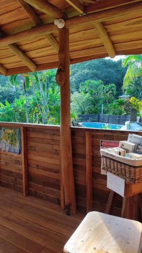 a wooden porch with a view of a swimming pool at Finca Colibri Ecolodges en Pleine Nature ferry Playa Najanjo Costa Rica in Cabo Blanco