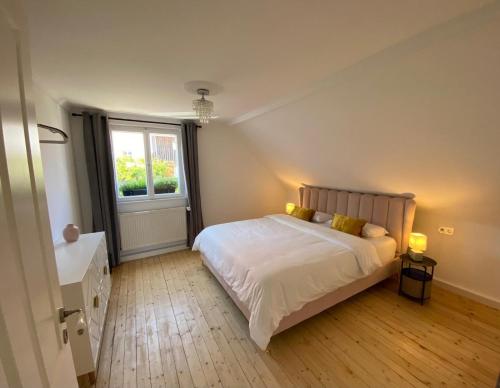 a bedroom with a large white bed and a window at Cottage Sleeps 6 with Parking in Lupburg