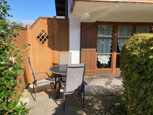 a patio with a table and chairs in front of a building at Ferienwohnung Eulennest in Bolsterlang