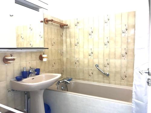 ein Badezimmer mit einem Waschbecken und einer Badewanne mit einem Waschbecken in der Unterkunft LE CASINO DES FLEURS - Hypercentre - Parking - Balcon in Vichy