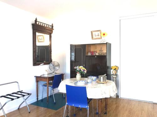 une salle à manger avec une table et des chaises bleues dans l'établissement LE CASINO DES FLEURS - Hypercentre - Parking - Balcon, à Vichy