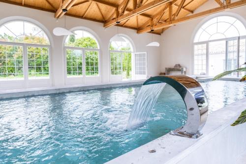 une piscine intérieure avec toboggan dans une maison dans l'établissement Secret d'Uzès - Le Duché - Piscine chauffée et Jacuzzi, à Uzès