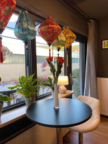 a table with flowers in a room with windows at 1 grosse elegante Zimmerwohnung 5 Minuten zu Fuss in die Stadtmitte in Lörrach