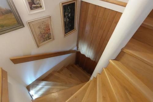 a stairway with wooden floors and paintings on the wall at Klasický dům, 5 ložnic , 5 bedrooms, Praha in Prague