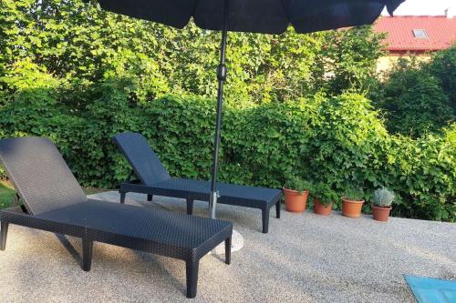 two chairs and an umbrella on a patio at Klasický dům, 5 ložnic , 5 bedrooms, Praha in Prague