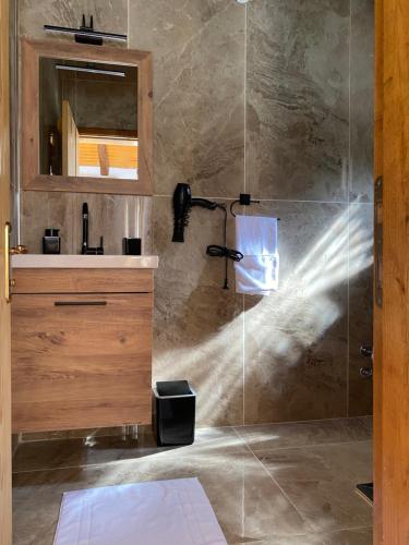 KüçükköyにあるVadi Konaklamaの洗面台と鏡付きのシャワーを備えたバスルーム