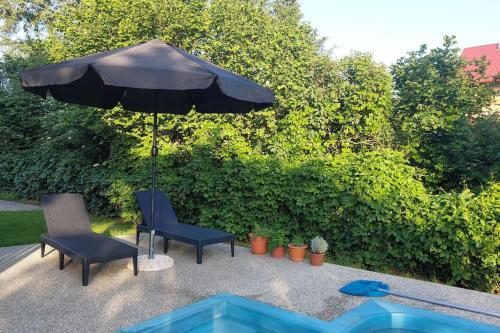 a patio with two chairs and an umbrella at Klasický dům, 5 ložnic , 5 bedrooms, Praha in Prague
