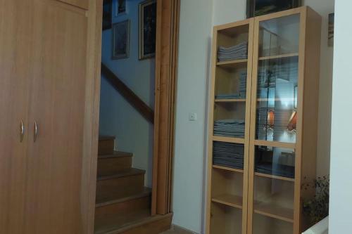a hallway with a glass cabinet next to a staircase at Klasický dům, 5 ložnic , 5 bedrooms, Praha in Prague