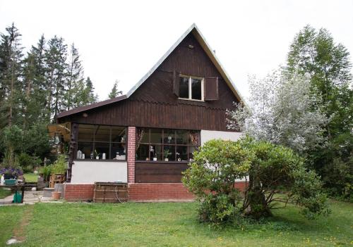 a large wooden house with a large window at Chata Na Palouchu in Komorovice