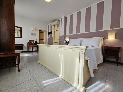 a bedroom with a bed with a striped wall at Hotel Rosalba Perugia in Perugia