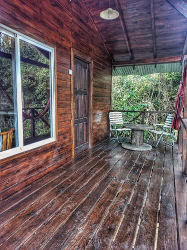 a porch of a cabin with a picnic table and windows at Cabaña Megara en Complejo Marea in Tigre