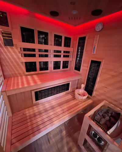 an empty sauna with red lights in a room at Closerie 3 étoiles La Poire à Loup, Domaine avec Piscine in Vaulandry
