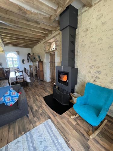 a living room with a fireplace and a blue chair at Closerie 3 étoiles La Poire à Loup, Domaine avec Piscine in Vaulandry