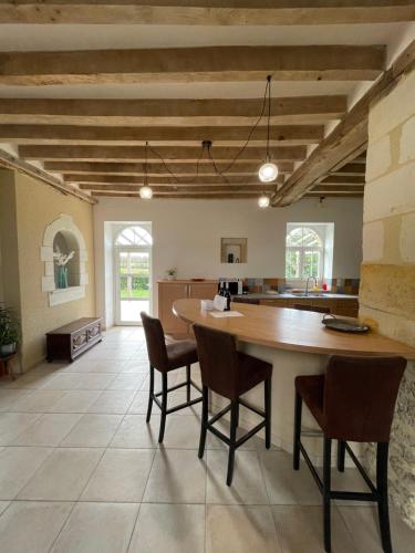 a kitchen with a large wooden table and chairs at Closerie 3 étoiles La Poire à Loup, Domaine avec Piscine in Vaulandry