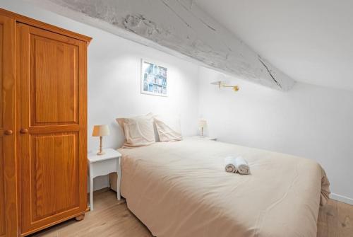 - une chambre avec un lit blanc et une armoire en bois dans l'établissement Aurore - T1 spacieux - 31, à Carcassonne