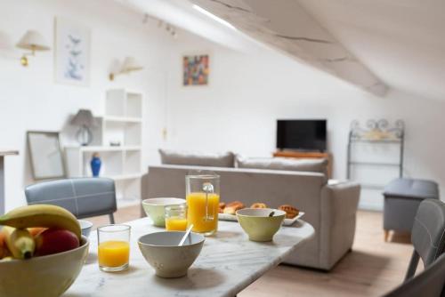- une table avec un bol de fruits et des verres de jus d'orange dans l'établissement Aurore - T1 spacieux - 31, à Carcassonne