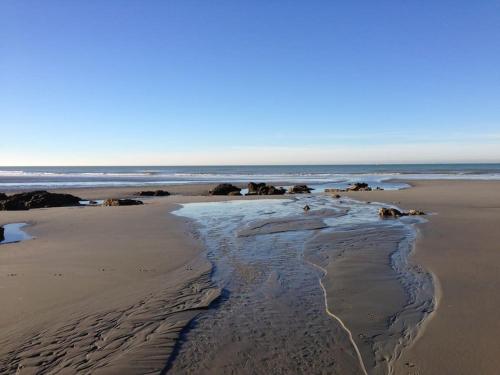 a beach with a stream of water in the sand at Maison à 300m de la mer Wimereux in Wimereux