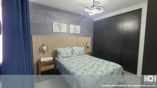 a bedroom with a bed with a blue comforter at Exclusivo céntrico en la Trinitaria in Santiago de los Caballeros