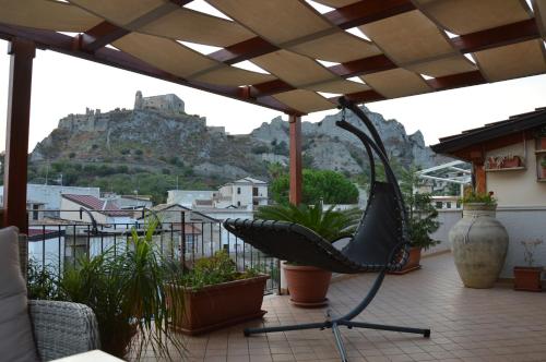 a chair on a balcony with a mountain in the background at B&B e Casa Vacanza al Castello in Roccella Ionica