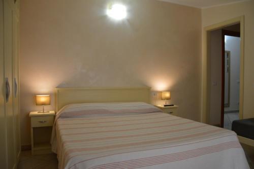 a bedroom with a bed and two lamps on tables at B&B e Casa Vacanza al Castello in Roccella Ionica