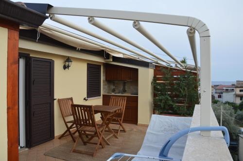 a pergola on a patio with a table and chairs at B&B e Casa Vacanza al Castello in Roccella Ionica