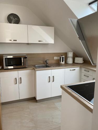 a kitchen with white cabinets and a microwave at Heimathafen in Eckernförde