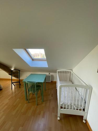 a small room with a table and a crib at Closerie 3 étoiles La Poire à Loup, Domaine avec Piscine in Vaulandry