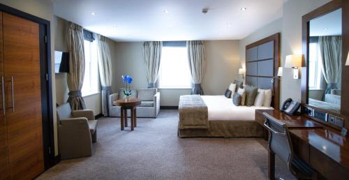 a large hotel room with a bed and a couch at Wellington Hotel by Blue Orchid in London