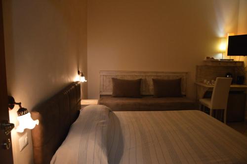 a bedroom with two beds and a table with a chair at B&B e Casa Vacanza al Castello in Roccella Ionica