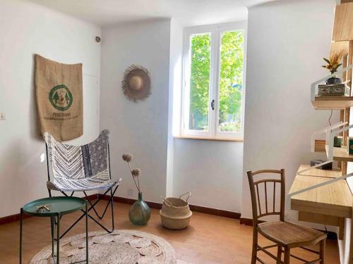 une chambre avec deux chaises, une table et une fenêtre dans l'établissement Maison vigneronne 4-6pers proche lamalou-les-bains, à Taussac-la-Billière