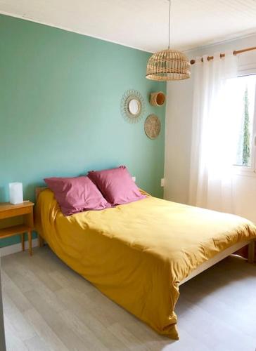 - une chambre avec un lit doté de draps jaunes et d'oreillers roses dans l'établissement Maison vigneronne 4-6pers proche lamalou-les-bains, à Taussac-la-Billière